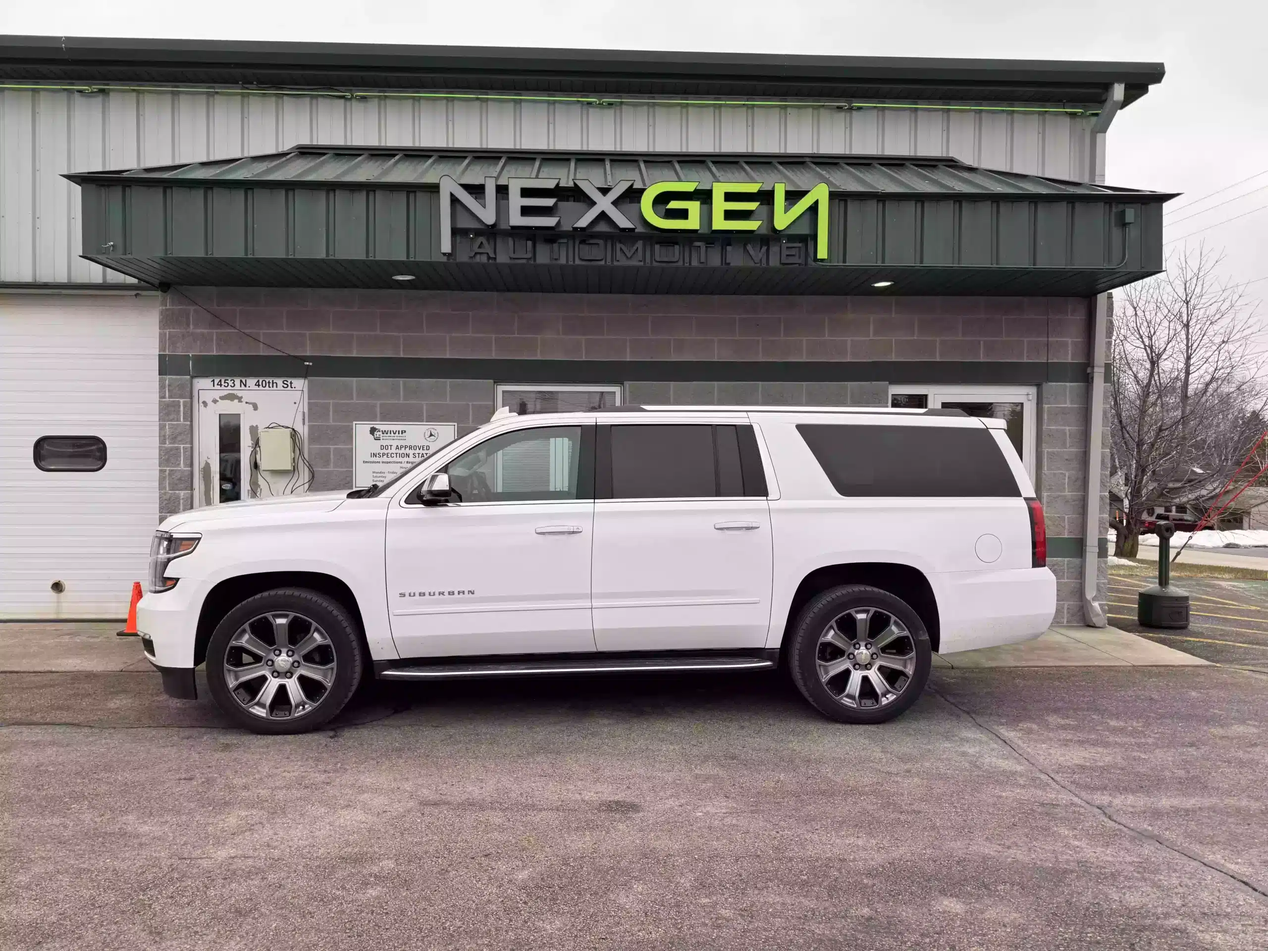 3/36 Warranty in Sheboygan WI, by NexGen Automotive. Front view of NexGen Automotive's shop in Sheboygan, WI, with a white Chevrolet Suburban parked in front, highlighting the quality auto repair services provided by NexGen and their 3/36 Warranty program.