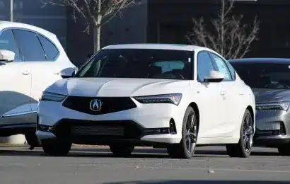 A white sedan parked outdoors in a car lot, showcasing its sleek design and elegance.