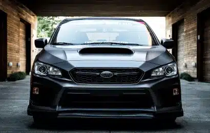 A sedan parked in a modern driveway, showcasing its sporty front design and aggressive stance.