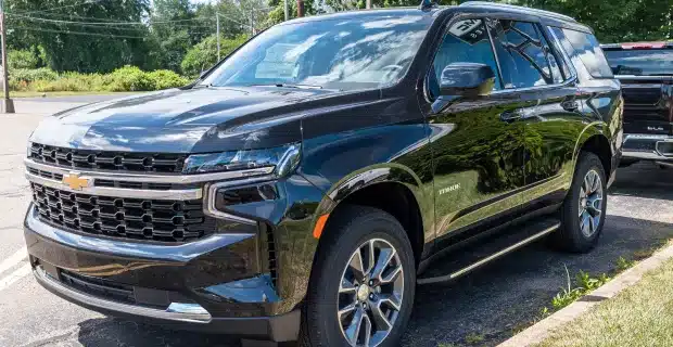 A black Chevrolet SUV parked in an outdoor lot, showcasing its sturdy design and spacious build.