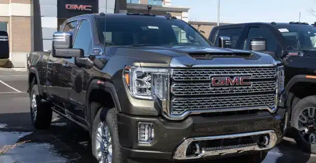 A gray GMC truck parked in front of a dealership, showcasing its powerful build and rugged design.