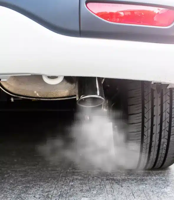 A car's exhaust emitting fumes during an emissions test. This image highlights the importance of regular emissions testing to ensure vehicles meet environmental standards and reduce pollution.