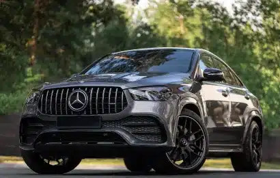 A sleek black Mercedes-Benz SUV parked outdoors, surrounded by greenery, highlighting its luxury and design.