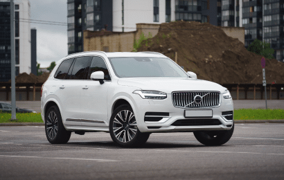 A white Volvo SUV parked in an urban area, showcasing its modern design and elegance.