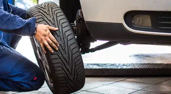 Changing a tire during a pre-trip inspection to ensure vehicle safety and performance.