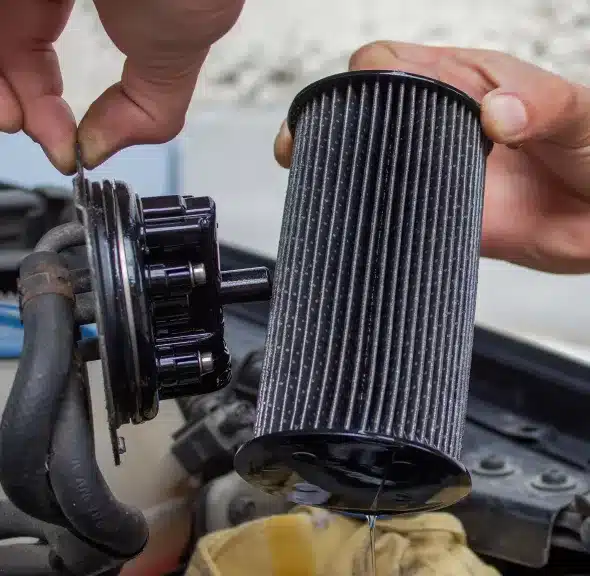 Vehicle Maintenance in Sheboygan WI, by NexGen Automotive. Image of person's hands installing a new vehicle air filter during routine maintenance. This image emphasizes the importance of regular maintenance to keep the vehicle running smoothly and efficiently.