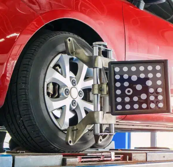 Aligning a car's wheels with precision using modern equipment to ensure proper alignment and balance for optimal vehicle performance and tire longevity.