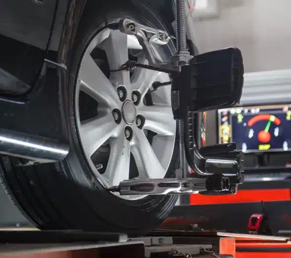 Wheel Alignment in Sheboygan WI, by NexGen Automotive. Image of technician adjusting the alignment of a car wheel on a professional alignment machine.