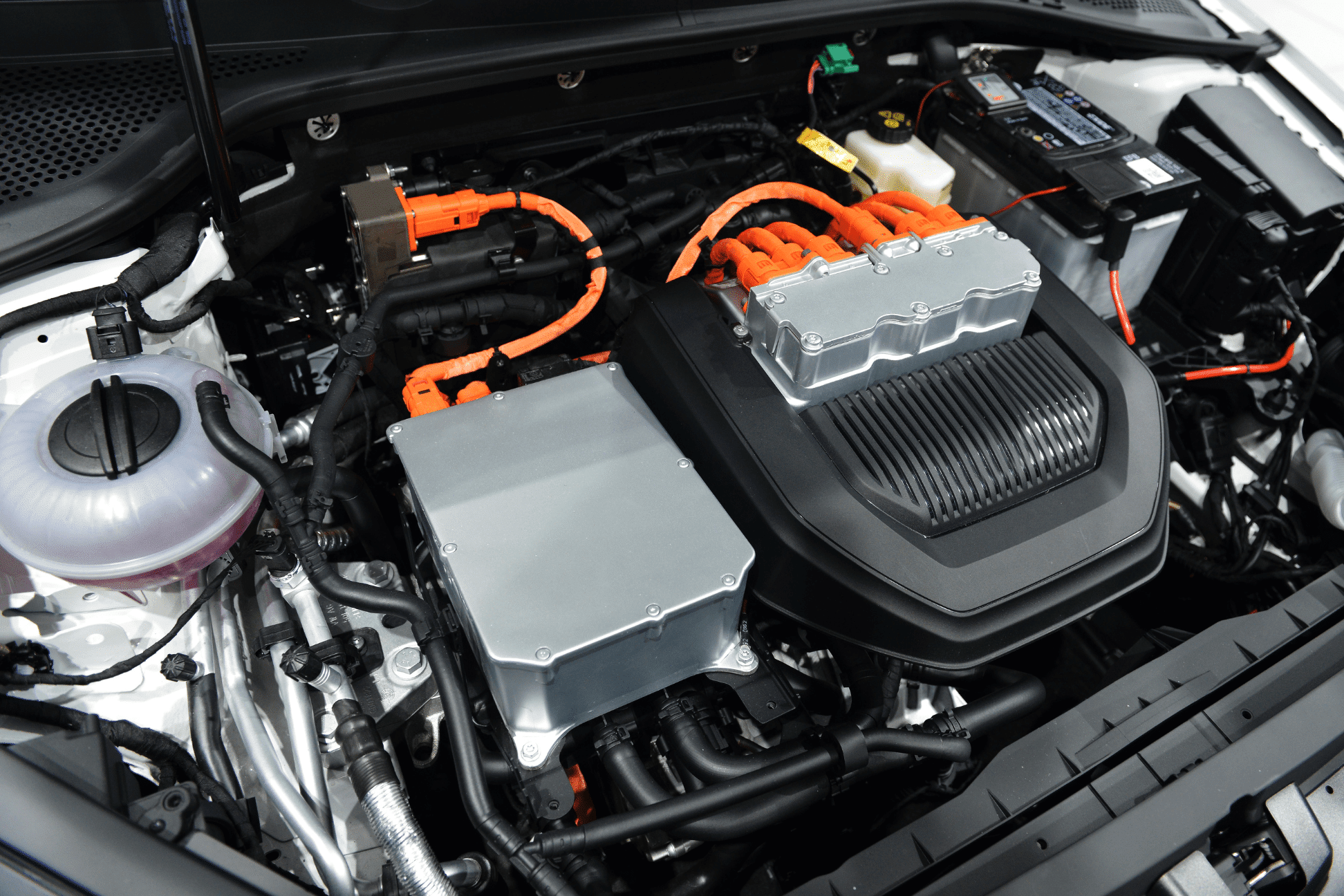 What Sheboygan Drivers Should Know About Electric Vehicle Diagnostics. Close-up of an electric vehicle's engine bay, highlighting components like battery packs, orange high-voltage cables, and power management systems, emphasizing the complexity of EV technology.