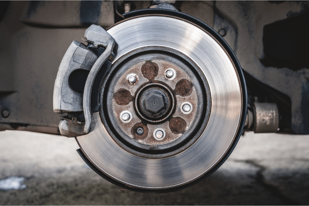brake noise, auto repair in Sheboygan, WI at NexGen Automotive. Close-up of a car's brake rotor and caliper assembly. Ideal for showcasing brake repair services and emphasizing vehicle safety and precision maintenance.