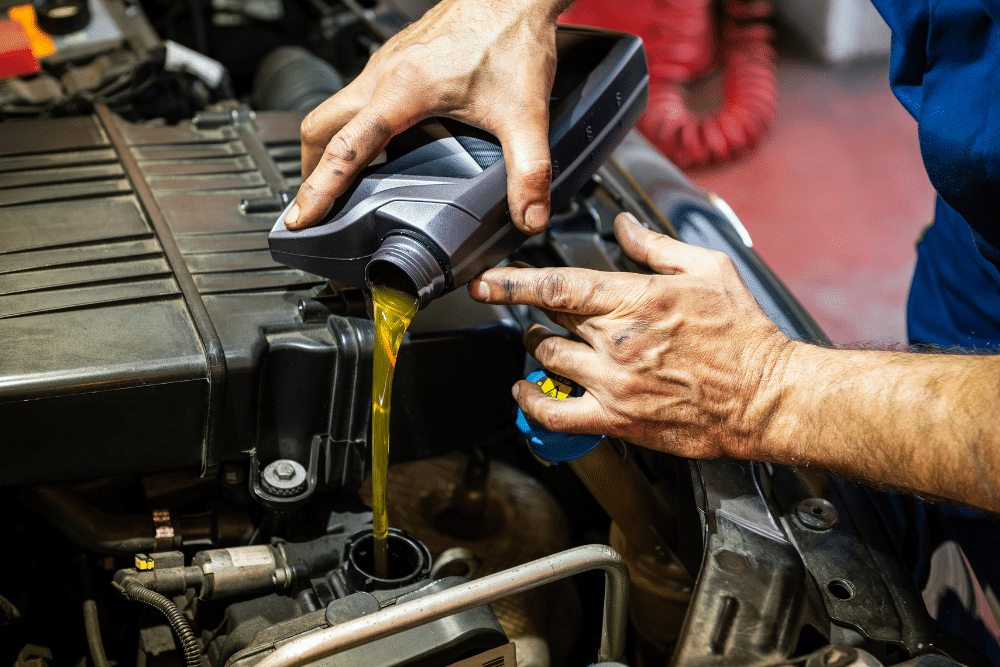 Why Preventative Maintenance is Essential in Sheboygan, WI at NexGen Automotive. Image of a technician pouring fresh oil into an engine, highlighting the shop’s commitment to proper lubrication and reliable vehicle performance.