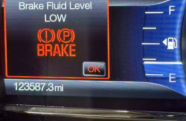 Brake fluid level warning light illuminated on a car dashboard, indicating the need for a brake fluid flush. Trust NexGen Automotive in Sheboygan, WI for top-tier service and regular brake fluid maintenance.