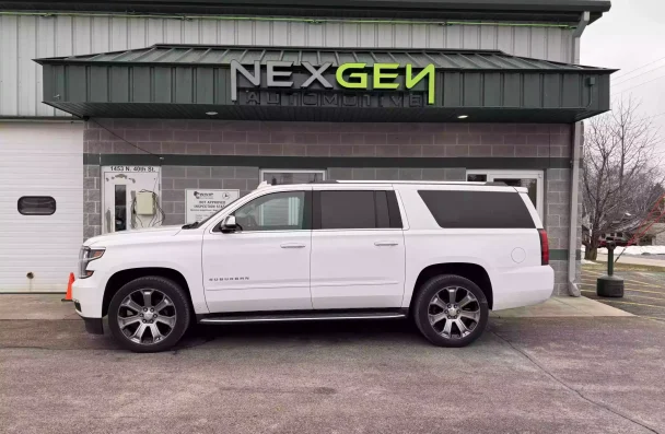 3/36 Warranty in Sheboygan WI, by NexGen Automotive. Front view of NexGen Automotive's shop in Sheboygan, WI, with a white Chevrolet Suburban parked in front, highlighting the quality auto repair services provided by NexGen and their 3/36 Warranty program.