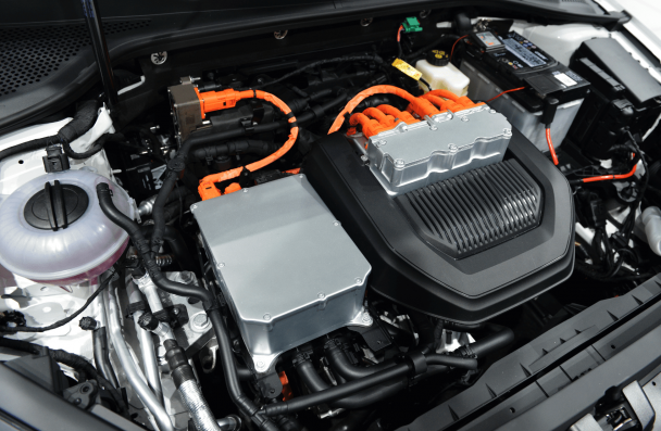 What Sheboygan Drivers Should Know About Electric Vehicle Diagnostics. Close-up of an electric vehicle's engine bay, highlighting components like battery packs, orange high-voltage cables, and power management systems, emphasizing the complexity of EV technology.