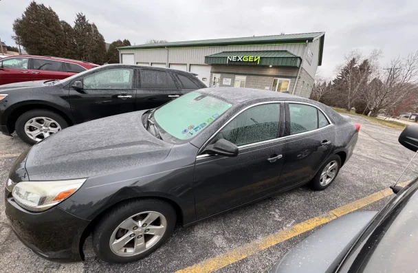 New car purchase guidance by NexGen Automotive in Sheboygan, WI: Parked vehicles outside NexGen Automotive's facility, emphasizing the importance of understanding the costs and factors involved in buying a new car.